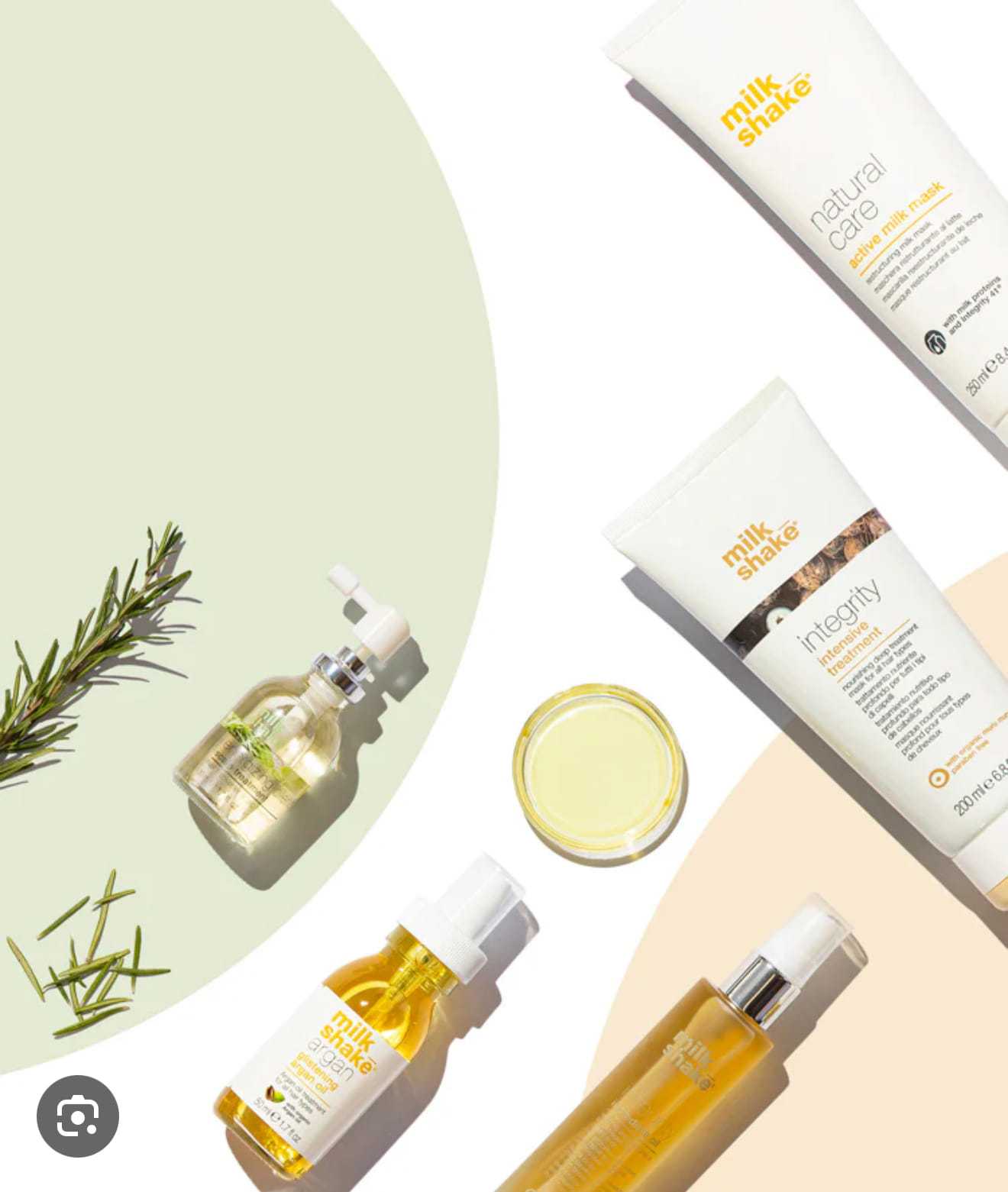 Milkshake hair care products and rosemary sprigs on a pastel background.